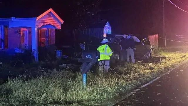 Law enforcement and emergency responders at a crash scene after a truck hit a house