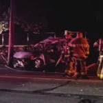 Damaged car wreckage near a utility pole and stone wall after a fatal Middletown crash